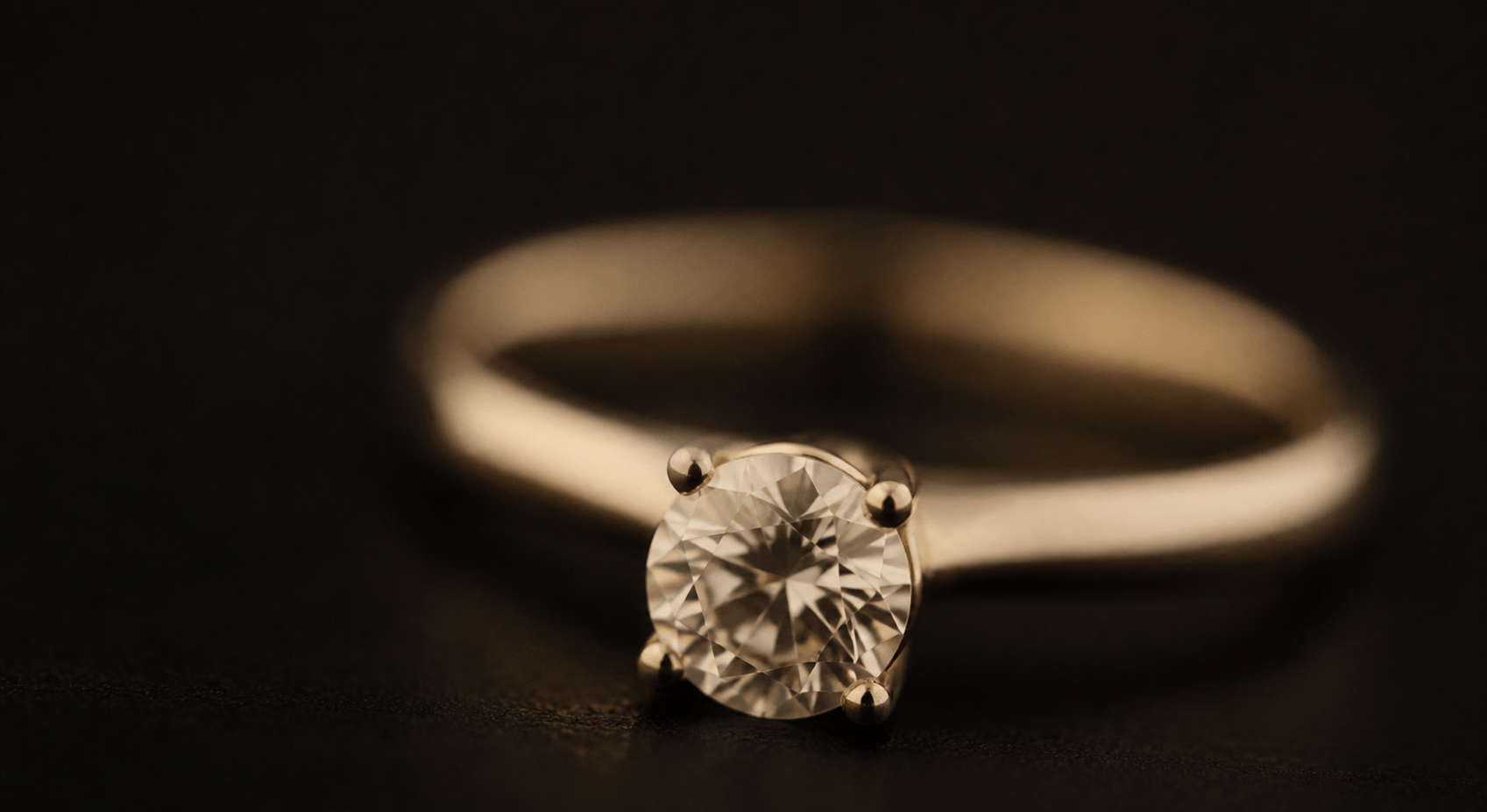 Full-bleed mood photograph - ring or diamond, dark background