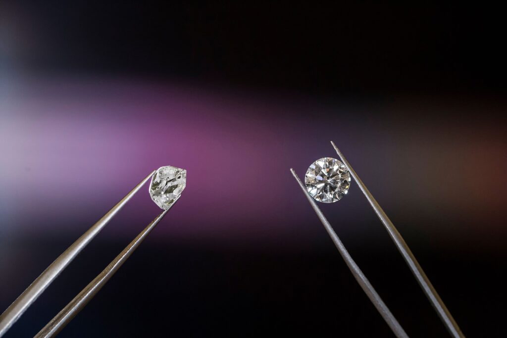 Rough and cut diamonds in tweezers.